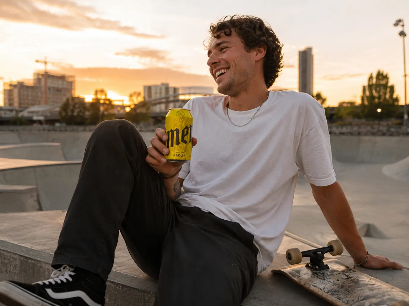 Skater relaxing at sunset with an Amen Radler can